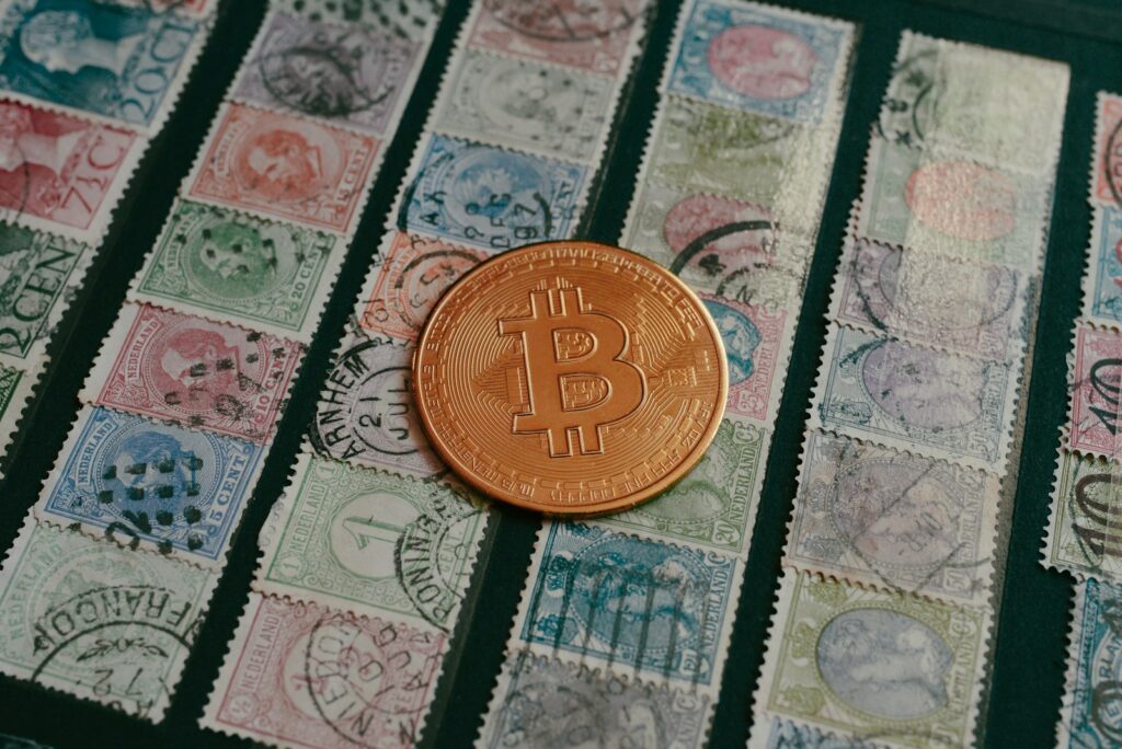 a bit coin sitting on top of a pile of stamps